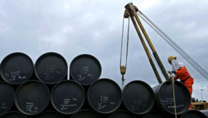 Un trabajador trabaja transportando barriles de petróleo.