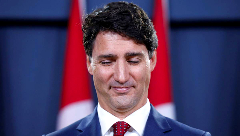 Justin Trudeau, primer ministro de Canadá, con una leve sonrisa y mirando al suelo