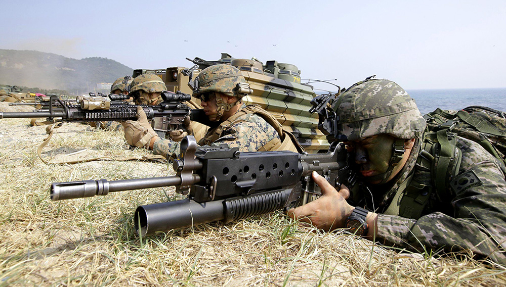 In this March 30, 2015, file photo, marines of South Korea, right, and the U.S aim their weapons near amphibious assault vehicles during U.S.-South Korea joint landing military exercises.