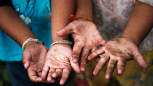 Trabajo infantil, dos niños muestran sus manos abiertas y sucias