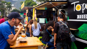 Personas comiendo en El Topocho Food Truck. En medio de la crisis, los "food trucks" ganan terreno en Caracas. EFE/Miguel Gutiérrez