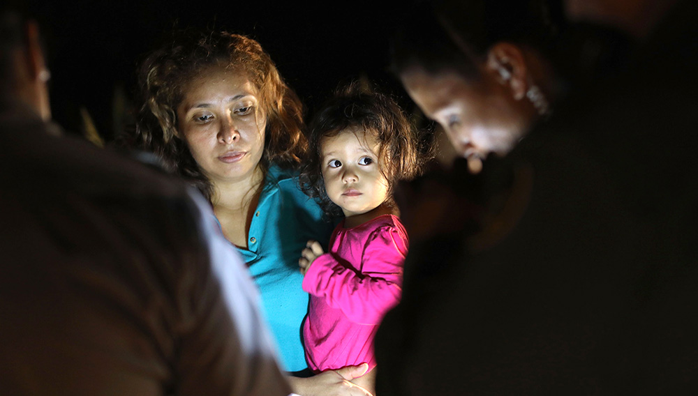 MCALLEN, TX - JUNE 12: Central American asylum seekers, including a Honduran girl, 2, and her mother, are taken into custody near the U.S.-Mexico border on June 12, 2018 in McAllen, Texas. The group of women and children had rafted across the Rio Grande from Mexico and were detained by U.S. Border Patrol agents before being sent to a processing center for possible separation. Customs and Border Protection (CBP) is executing the Trump administration's zero tolerance policy towards undocumented immigrants. U.S. Attorney General Jeff Sessions also said that domestic and gang violence in immigrants' country of origin would no longer qualify them for political asylum status. (Photo by John Moore/Getty Images)