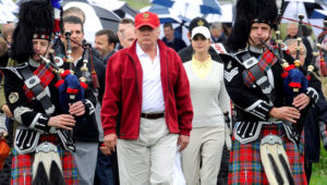 A picture taken on July 10, 2012 shows US tycoon Donald Trump (C) escorted by Scottish pipers as he officially opens his new multi-million pound Trump International Golf Links course in Aberdeenshire, Scotland. Over 70,000 people had on December 9, 2015 signed a petition to ban US presidential hopeful Donald Trump from entering Britain following his call to bar Muslims from entering the United States. AFP PHOTO / Andy Buchanan