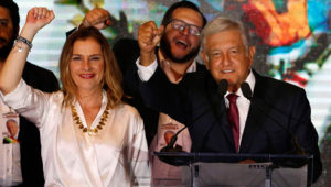 Presidential candidate Andres Manuel Lopez Obrador waves to supporters as he gives his first victory speech at his campaign headquarters at the Hilton hotel in Mexico City, Sunday, July 1, 2018. Lopez Obrador has claimed victory in Mexico's presidential election, calling for reconciliation. At left is his wife,Beatriz Gutierrez Muller. (AP Photo/Marco Ugarte)