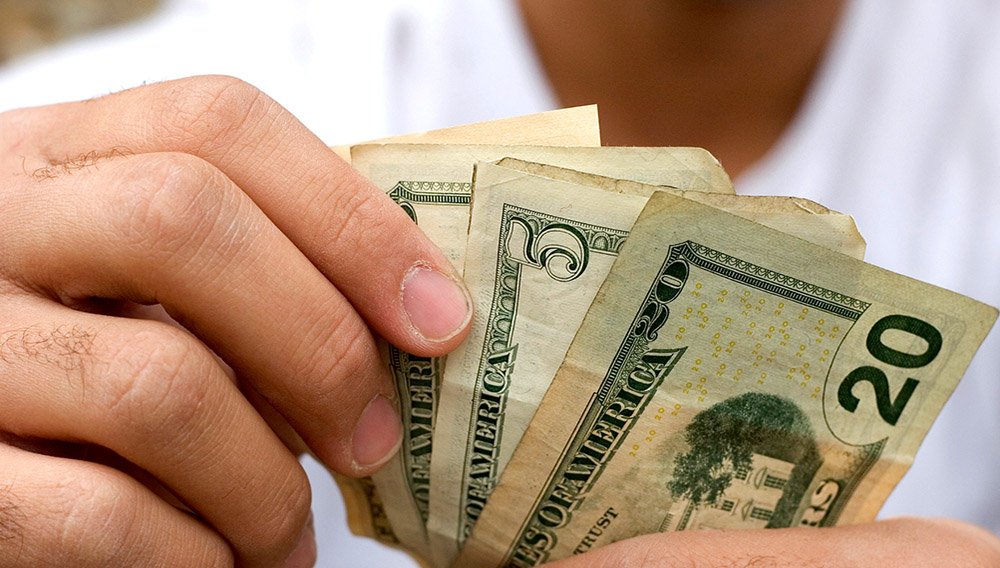 Money counting, young adult. JASON STITT VIA GETTY IMAGES