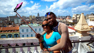 A local couple takes a selfie on a rooftop in Old Havana. In the background is El Capitolio, an almost identical twin to the US Capitol building in Washington DC. (Credit: Oded Wagenstein)