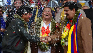 Los mandatarios de Bolivia, Evo Morales (iz.) y de Venezuela, Nicolás Maduro (der.) se saludan mientras el entonces presidente ecuatoriano Rafael Correa ríe en la ceremonia de bienvenida a los delegados del G77+China en Santa Cruz, Bolivia, el 14 de junio del 2014. AP.
