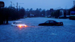 An abandoned car's hazard lights continue to flash as it sits submerged in rising flood waters during pre-dawn hours Saturday after Florence struck in Wilmington. PHOTO: JONATHAN DRAKE/REUTERS