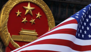 An American flag is flown next to the Chinese national emblem during a welcome ceremony for visiting U.S. President Donald Trump CREDIT: AP