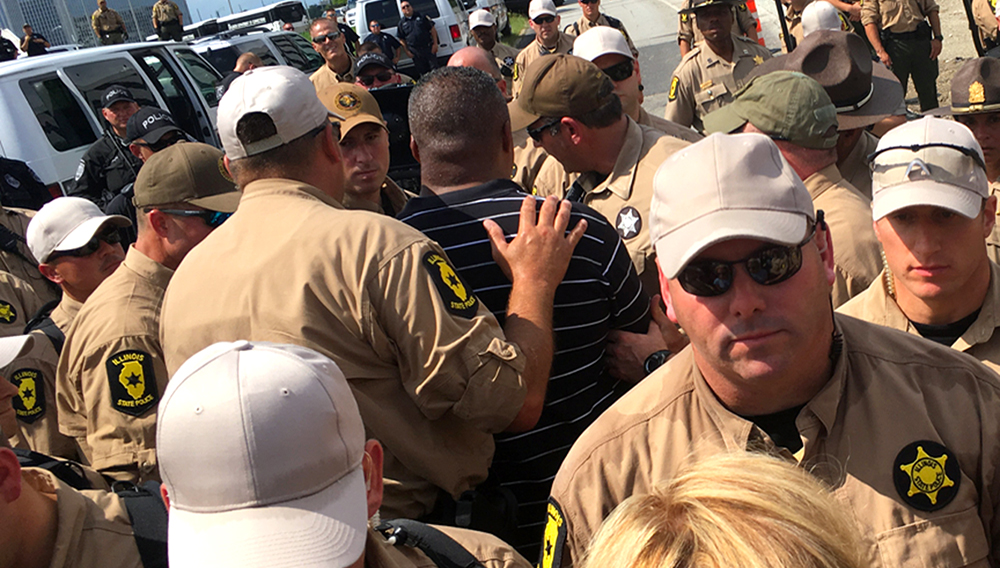 The Rev. Gregory Livingston (center) is arrested while protesting along a ramp leading onto the Kennedy expressway on Monday. | Tim Boyle/For the Sun-Times
