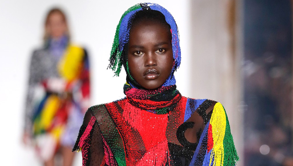 Model Adut Akech presented a wild Versace creation of swirling colors topped by a hood on the Fall 2018 catwalk - Feb 23, 2018.