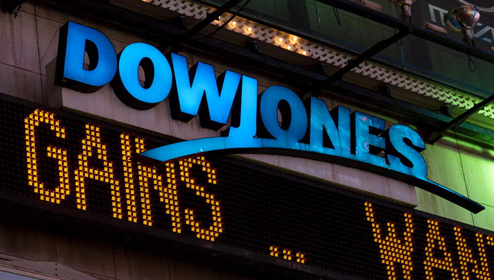 New York, USA - July 29, 2016: The illuminated Dow Jones sign in Times Square late in the night as the latest news streams on the led board.