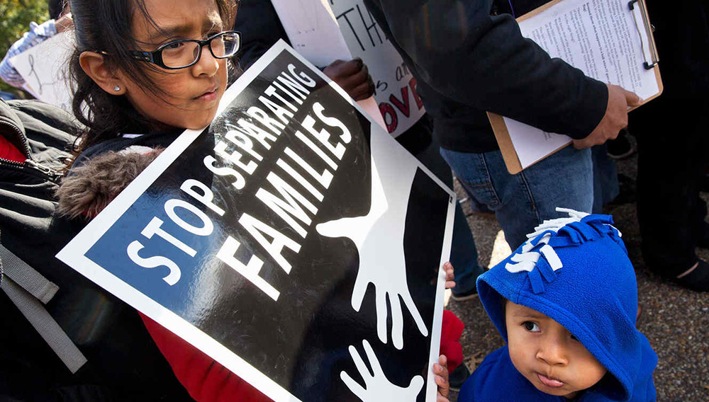 Niños con una pancarta con un mensaje en contra de separación de familias en la frontera sur de EEUU