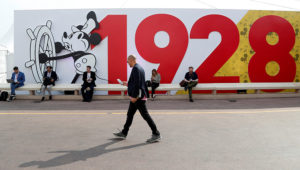 A visitor walks past a mural depicting Disney character Mickey Mouse to celebrate his 90th birthday during the annual MIPCOM television programme market in Cannes, France, October 15, 2018. REUTERS/Eric Gaillard
