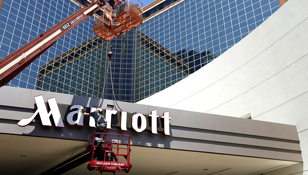 Un hombre trabaja en un letrero de la cadena de hoteles Marriott en Little Rock, Arkansas, el 30 de abril de 2013. (AP Foto/Danny Johnston, File)
