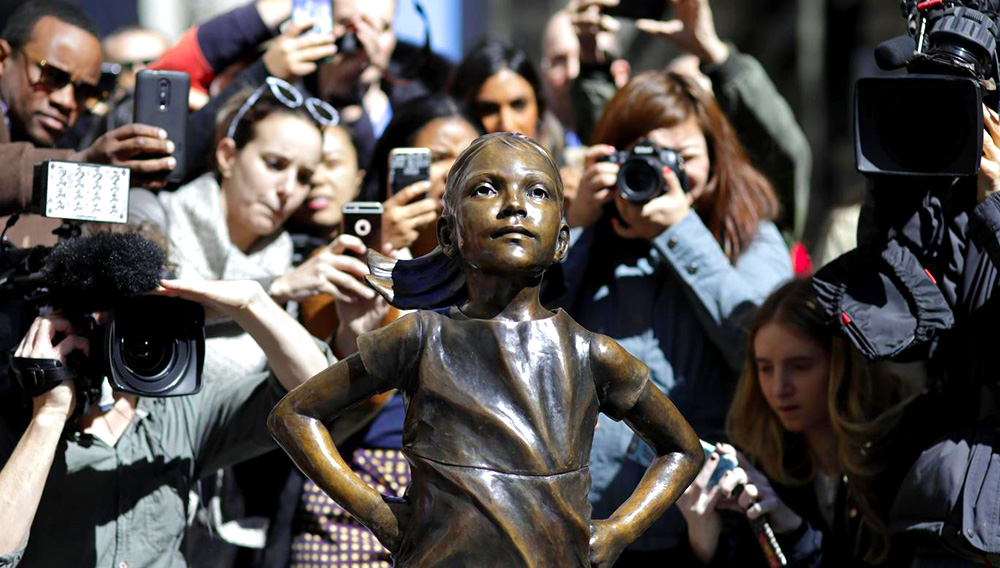 March 8, 2017. People stop to photograph the "Fearless Girl" statue in New York. AP