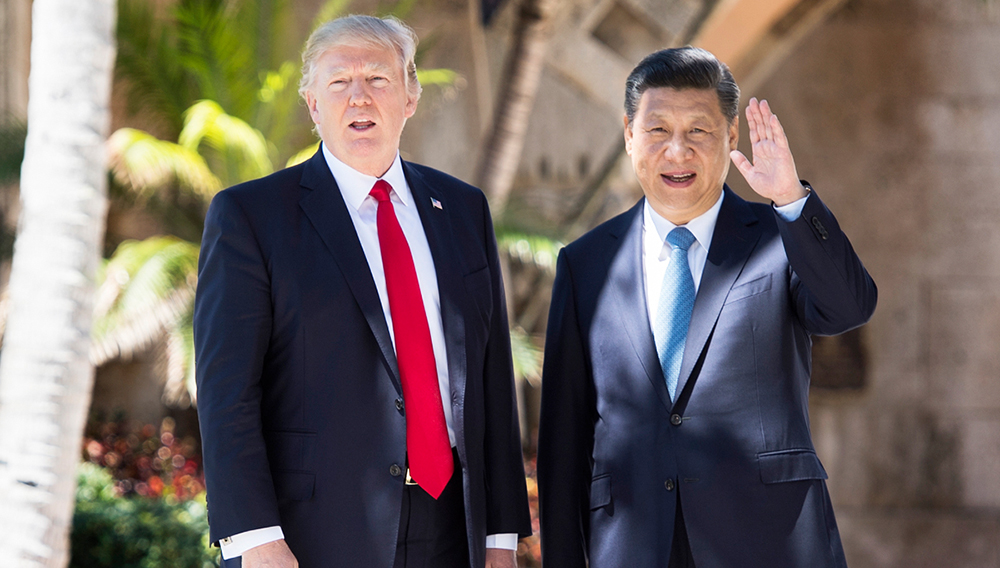 Chinese President Xi Jinping (R) waves to the press as he walks with US President Donald Trump at the Mar-a-Lago estate in West Palm Beach, Florida, April 7, 2017. JIM WATSON / AFP