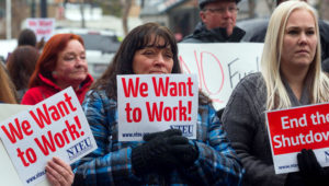 IRS employee Donna Orton (C) holds a sign protesting the government shutdown on January 10, 2019 in Ogden, Utah. None of these workers received their wages on January 11. Natalie Behring, Getty Images, AFP