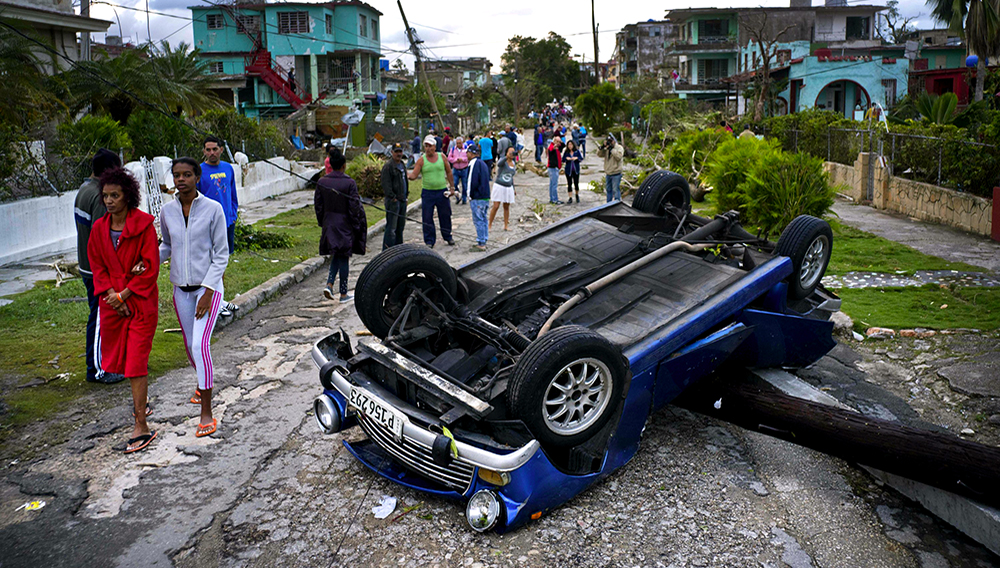 Un vehículo volteado por la fuerza de un tornado en una calle de La Habana, Cuba, el lunes 28 de enero de 2019. Un tornado y fuertes lluvias azotaron el este de la capital cubana la madrugada del lunes derribando árboles y doblando postes de luz. (AP Foto/Ramon Espinosa)