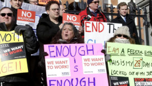 Varios empleados federales y simpatizantes protestan frente al capitolio en Boston, el jueves 17 de enero de 2019, en demanda de que se ponga fin al cierre parcial del gobierno federal. (AP Foto/Steven Senne)