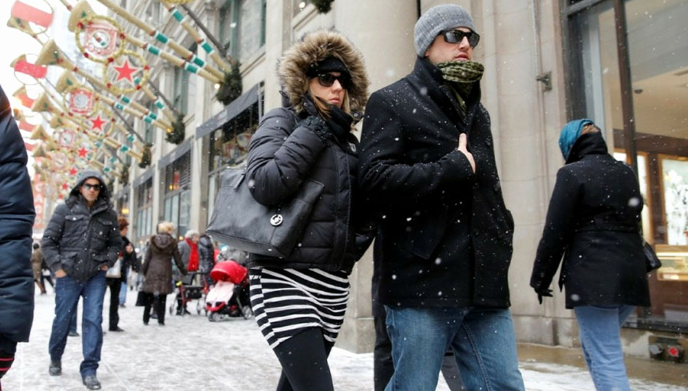 Nicole and Lee Richard, of Buffalo, N.Y., look cool in their sunglasses walking along State Street by Macy's Department Store in Chicago on Sunday. — Chuck Berman / Chicago Tribune, Dec. 8, 2013