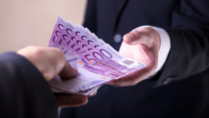Man in Men's Suits.Bribe and corruption with euro banknotes. Shutterstock