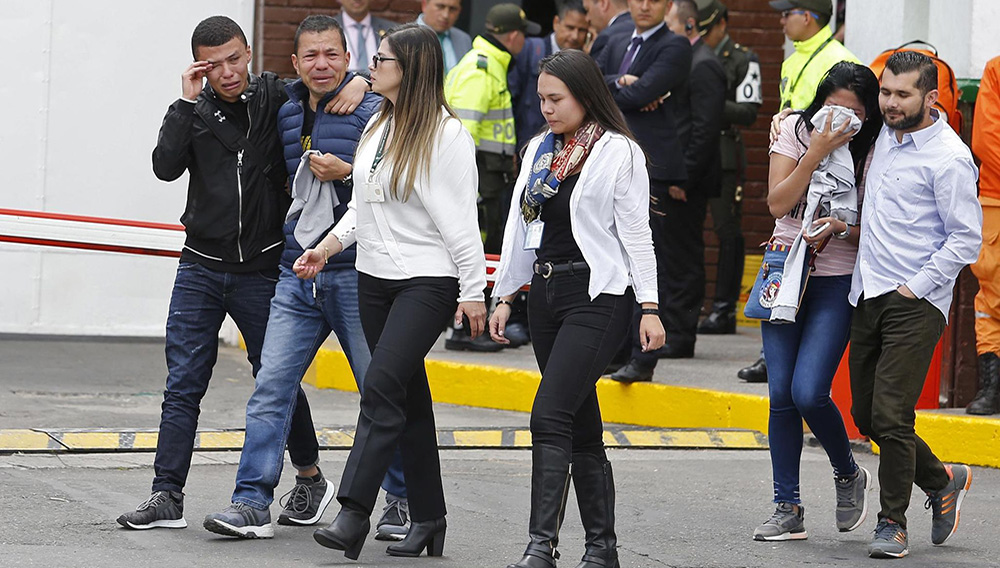 Familiares de las víctimas de un atentado con bomba lloran frente a la entrada de la academia de policía General Santander, donde tuvo lugar el ataque en Bogotá, Colombia, el jueves 17 de enero de 2019. (AP Foto/John Wilson Vizcaíno)