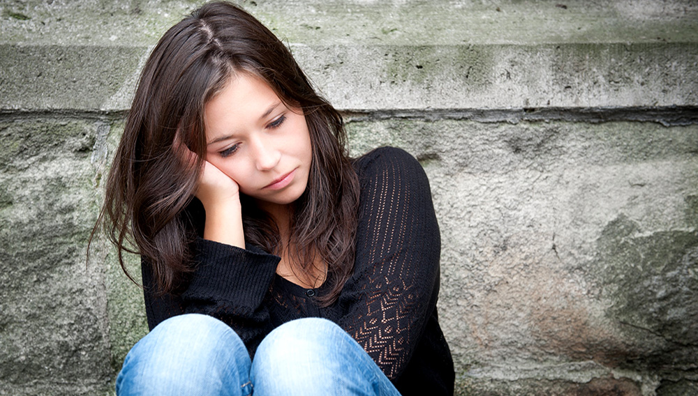 Outdoor Portrait eine traurige Teenager-Mädchen nachdenklich über Probleme suchen. Depositphotos.com