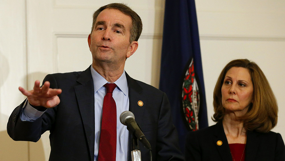 El gobernador de Virginia, Ralph Northam (izquierda), gesticula mientras su esposa, Pam, lo escucha durante una conferencia de prensa en Richmond, Virginia, el sábado 2 de febrero de 2019. (AP Foto/Steve Helber)