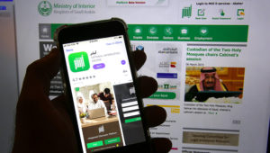 App del gobierno saudí Absher en un teléfono en Yeda, Arabia Saudí, 7 de marzo de 2019. Es principalmente un medio para pagar multas de tráfico y realizar otros trámites por vía electrónica. Pero también sirve para que los hombres den o nieguen permiso a las mujeres para viajar. (AP Foto/Amr Nabil)