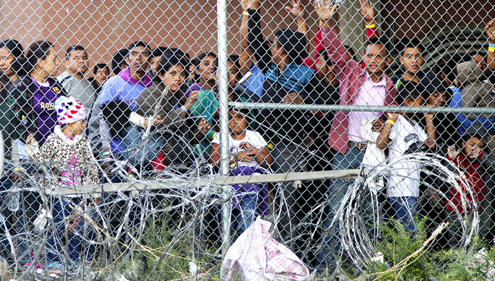 Migrantes centroamericanos esperan comida en El Paso, Texas, el miércoles 27 de marzo de 2019, dentro de una celda erigida por la Oficina de Aduanas y Protección Fronteriza. (AP Foto/Cedar Attanasio)