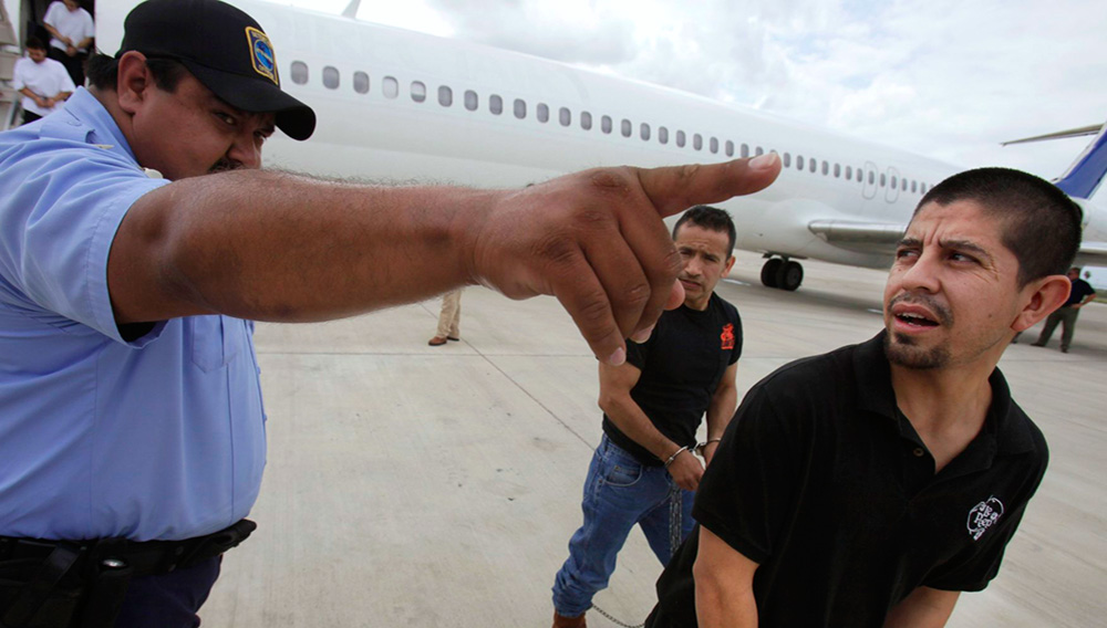 Shackled Mexican immigrants are directed by a guard to a waiting deportation by the U.S. Immigration and Customs Enforcement in Harlingen, Texas. (AP)
