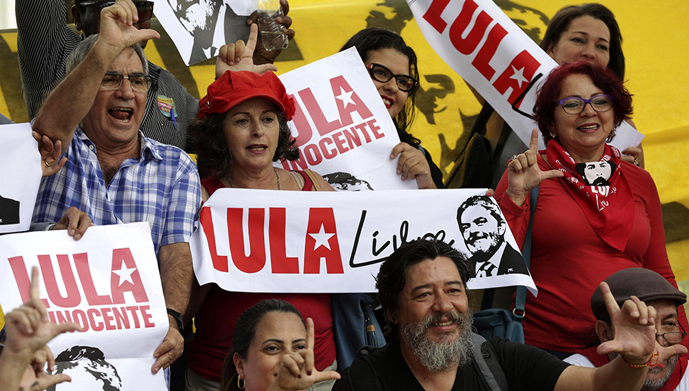Simpatizantes del expresidente brasileño Luiz Inácio Lula da Silva sostienen una pancarta con la leyenda "Lula Libre" y "Lula Inocente" durante una manifestación frente al Supremo Tribunal Federal en Brasilia, Brasil, el martes 23 de abril de 2019. (AP Foto/Eraldo Peres)