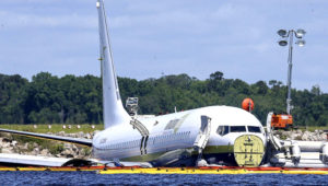 A charter plane carrying 143 people and traveling from Cuba to north Florida sits in a river at the end of a runway. (Gary McCullough / AP)