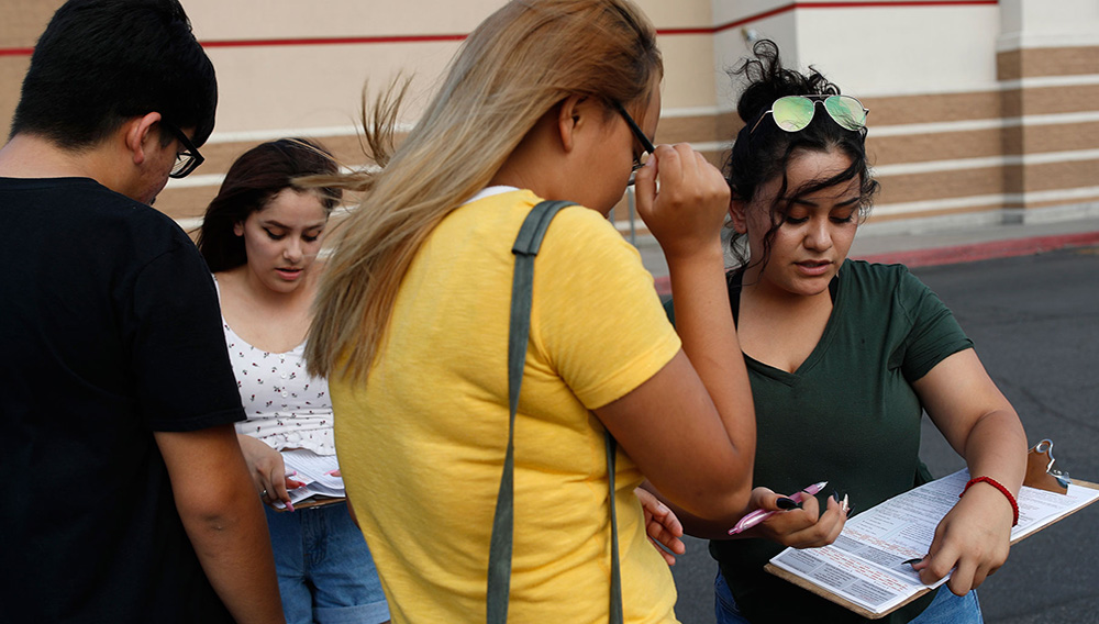 En esta foto del 15 de agosto de 2018, Maria Nieto, derecha, y Alma Romo, la segunda desde la izquierda, registran a las personas para votar en Las Vegas/AP