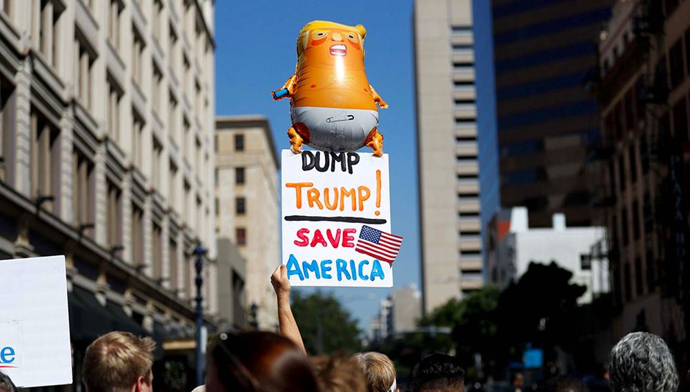 A group of people protesting a visit by President Donald Trump wait for his arrival to a fundraiser Wednesday, Sept. 18, 2019, in San Diego. Trump was scheduled to attend a fundraiser and visit the border before leaving later Wednesday. (AP Photo/Gregory Bull)
