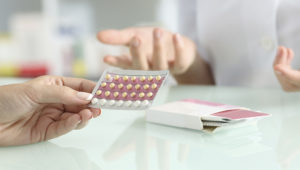 Close up of a girl hands buying contraceptive pills and pharmacist explaining in a pharmacy. Photo: Antonio Guillem