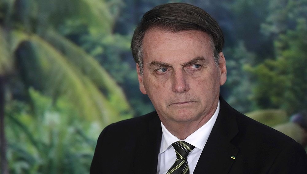 FILE - In this Oct. 1, 2019 file photo, President Jair Bolsonaro attends a ceremony to launch an agro program at the Planalto presidential palace in Brasilia, Brazil. Bolsonaro lashed out at journalists on Friday, Dec. 20 singling out one as looking like a homosexual, as news reports of a corruption investigation linked to his son continued making headlines. (AP Photo/Eraldo Peres, File)