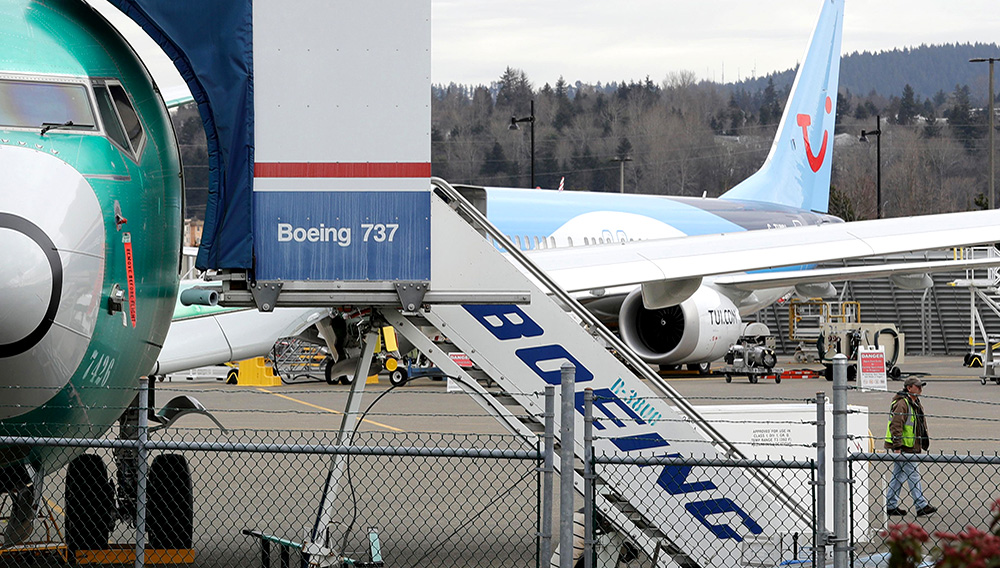 In this photo taken Monday, March 11, 2019, a Boeing 737 MAX 8 airplane being built for TUI Group sits parked in the background at right at Boeing Co.’s Renton Assembly Plant in Renton, Wash. (AP Photo/Ted S. Warren)