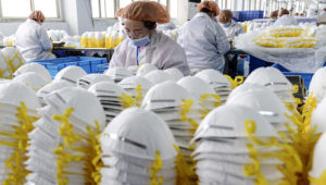 This photo taken on February 28, 2020 shows workers producing face masks at a factory in Handan in China's northern Hebei province. - The number of deaths globally in the new coronavirus outbreak passed 3,000 on March 2, as China reported more 42 deaths. (Photo by STR / AFP) / China OUT
