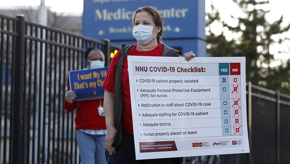 Members of the National Nurses Association, which includes registered nurses, outside the Brooklyn Veterans Administration Medical Center, Monday, April 6, 2020, in New York, where they called for more personal protective equipment (PPE) and staffing assistance to care for those affected by the current coronavirus outbreak. Photo: Kathy Willens