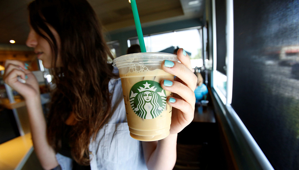 A patron holds an iced beverage at a Starbucks coffee store in Pasadena, Calif., July 25, 2013. | Reuters