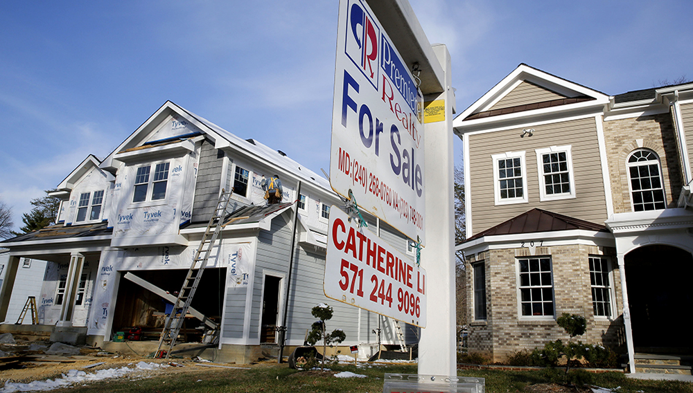A new home is being built next to a home with a for sale sign on a street in Vienna, on the morning the National Association of Realtors issues its Pending Home Sales for February report, in Virginia March 27, 2014. REUTERS/Larry Downing