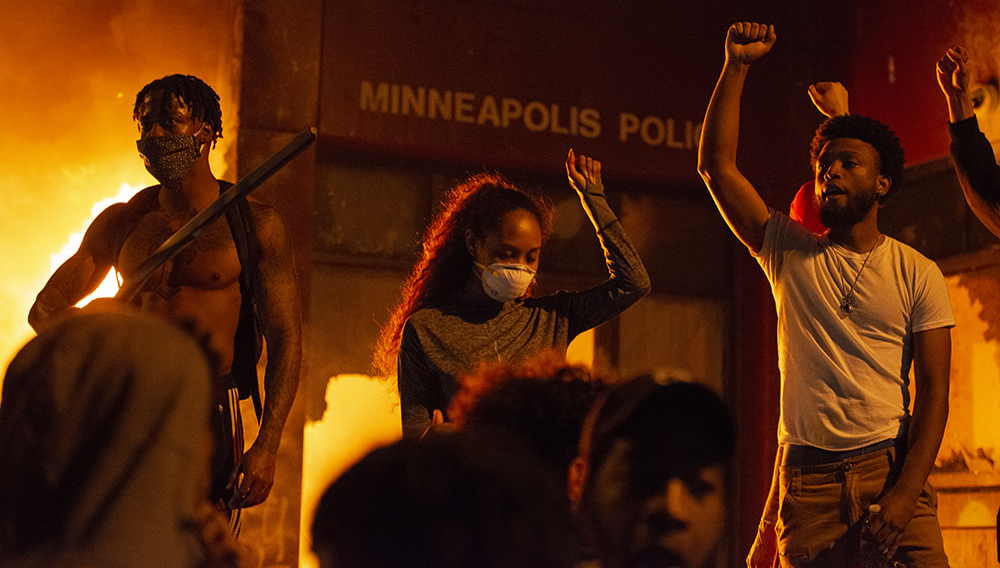 Protesters raise a fist in front of the burning Minneapolis 3rd police precinct on Thursday, May 28, 2020, during the third day of protests over the death of George Floyd in Minneapolis. | Anadolu Agency