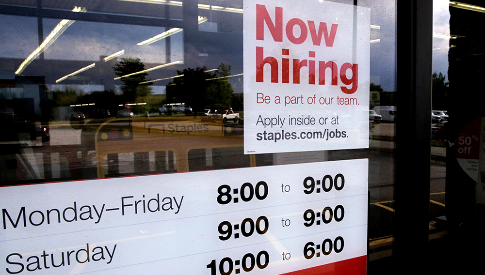 A “Now hiring” sign is displayed on the front door of a Staples store in Manchester, N.H., on Aug. 15, 2019. (Associated Press)