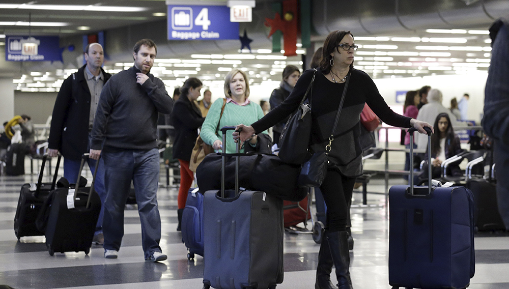 Travelers walk through Terminal 3 baggage claim at O'Hare International airport in Chicago on Dec. 1, 2013. | Nam Y. Huh, AP