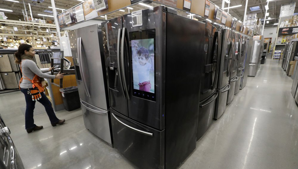 In this Jan. 27, 2020 file photo a worker pushes a cart past refrigerators at a Home Depot store location in Boston. On Thursday, June 25, orders to American factories for big-ticket goods rebounded last month from a disastrous May as the U.S. economy began to slowly reopen. (AP Photo/Steven Senne)