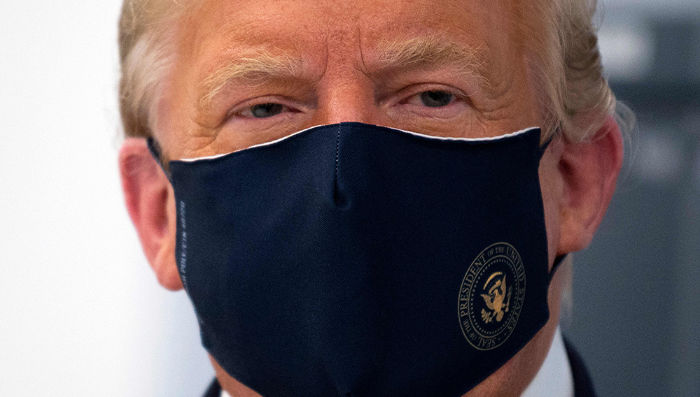 In this file photo US President Donald Trump wears a mask as he tours a lab where they are making components for a potential vaccine at the Bioprocess Innovation Center at Fujifilm Diosynth Biotechnologies in Morrisville, North Carolina on July 27, 2020. (Photo by JIM WATSON / AFP)