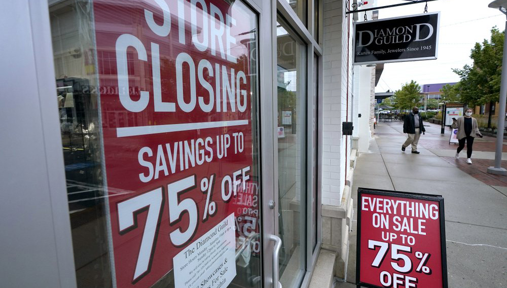 Passersby walk past a business storefront with store closing and sale signs, Wednesday, Sept. 2, 2020, in Dedham, Mass. The number of people seeking U.S. unemployment aid rose slightly to 870,000, a historically high figure that shows that the viral pandemic is still squeezing restaurants, airlines, hotels and many other businesses six months after it first erupted. (AP Photo/Steven Senne)