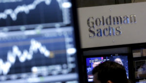 FILE - In this Oct. 16, 2014, file photo, a screen at a trading post on the floor of the New York Stock Exchange is juxtaposed with the Goldman Sachs booth. (AP Photo/Richard Drew, File)